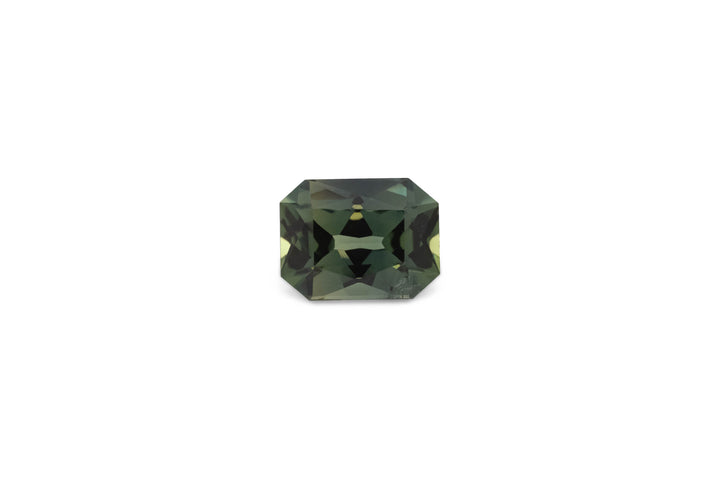 An emerald cut green Australian sapphire gemstone is displayed on a white background.