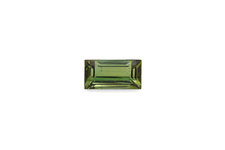 A baguette cut green tourmaline gemstone is displayed on a white background.