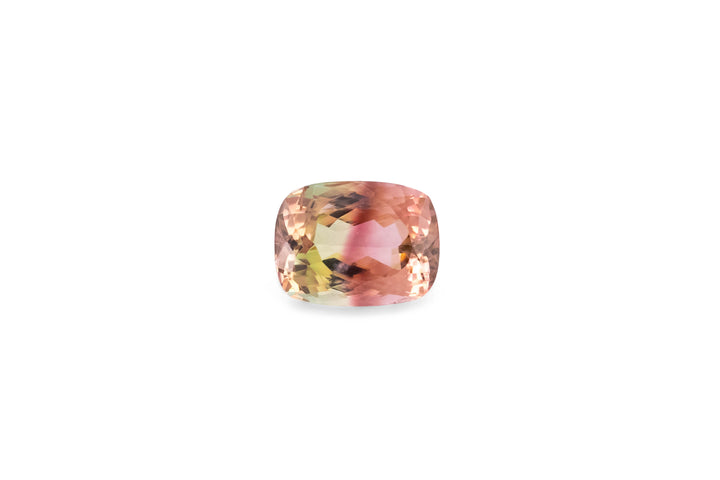 An cushopn cut bi-colour pink and yellow tourmaline gemstone is displayed on a white background.