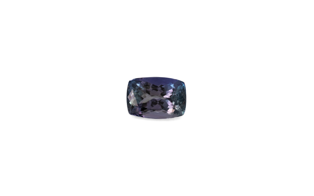 A cushion cut purple/blue and green unheated mermaid tanzanite gemstone is displayed on a white background. 