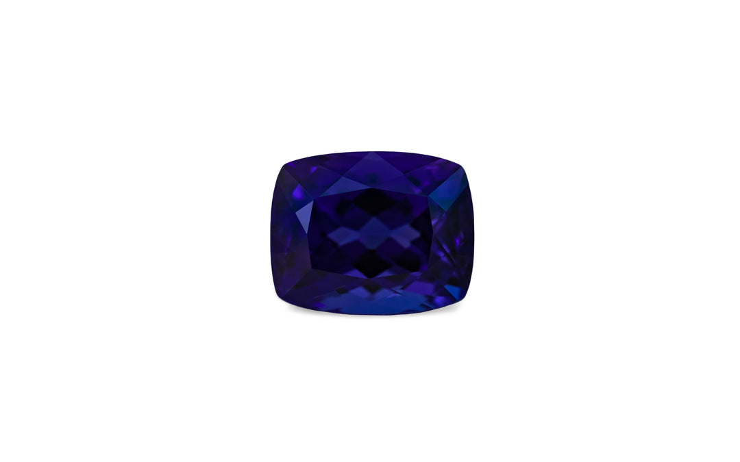 A cushion cut, vibrant blue colour tanzanite gemstone is displayed on a white background.