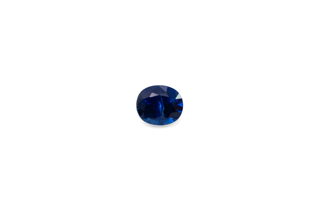 A cushion cut vivid blue Ceylon sapphire gemstone is displayed on a white background.