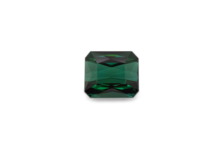An emerald cut green tourmaline is displayed on a white background.