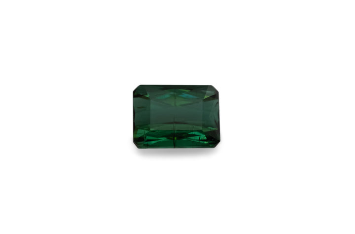 An emerald cut green tourmaline gemstone is displayed in a white background.