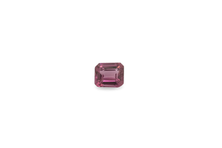 An  emerald cut pink tourmaline is displayed on a white background.