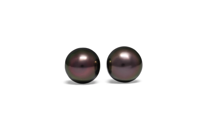 A high button pair of aubergine green Tahitian pearls are displayed on a white background.