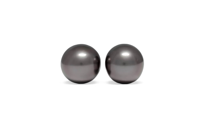 A pair of oval aubergine/green/silver tahitian pearls are displayed on a white background.