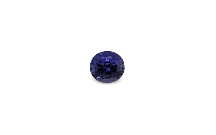 A oval cut purple blue ceylon sapphire gemstone is displayed on a white background.