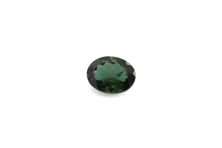 An oval cut green tourmaline is displayed on a white background.