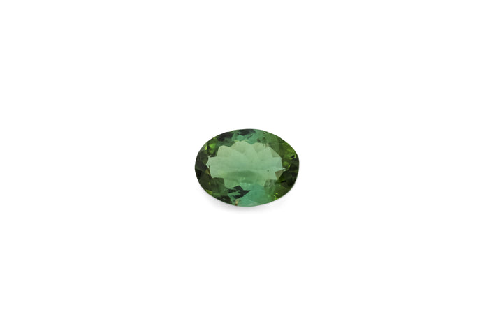 An oval cut green tourmaline is displayed on a white background.