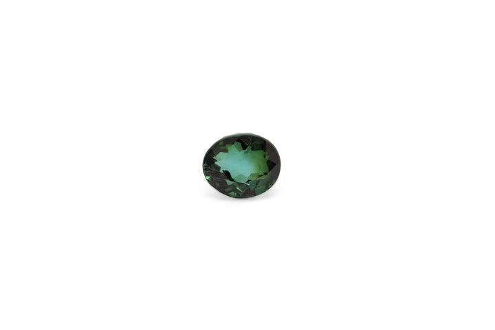 An oval cut green tourmaline gemstone is displayed on a white back ground.