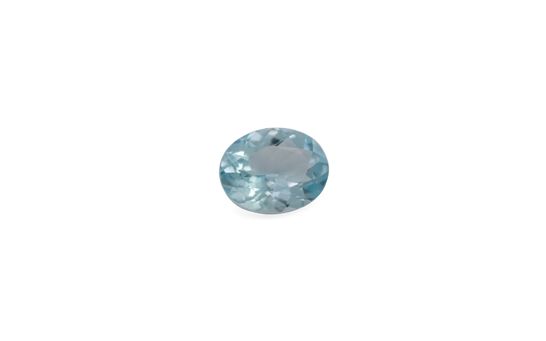 An oval cut pale blue aquamarine gemstone is displayed on a white background.