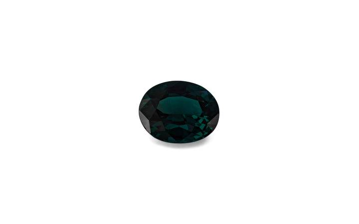 An oval cut teal spinel gemstone is displayed on a white background.