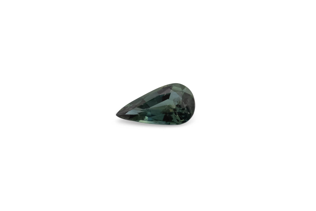 A faceted pear cut teal Australian sapphire gemstone is displayed on a white background.