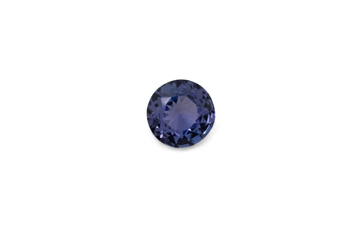 A round brilliant cut purple/blue tanzanite gemstone is displayed on a white background.
