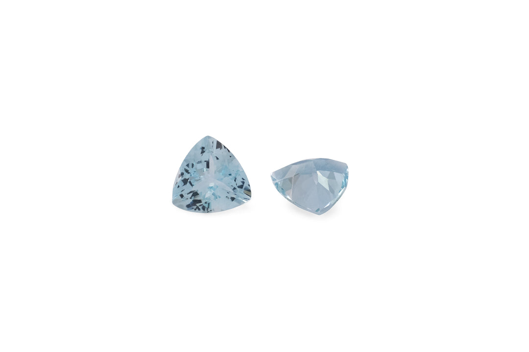 A pair of trillion cut pale blue aquamarine gemstones is displayed on a white background.