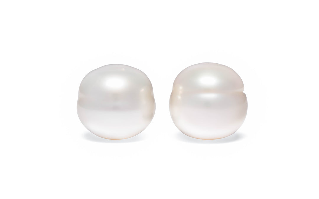 A  pair of circle white South Sea pearls are displayed on a white background.