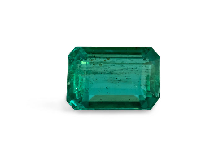 Emerald cut Brazilian emerald gemstone on a white background.