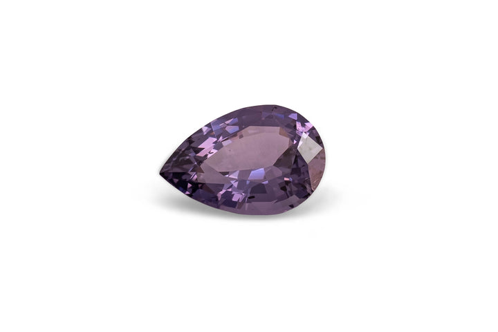 Pear cut purple Sri Lankan spinel gemstone on a white background.