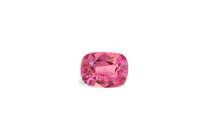 A cushion cut deep pink Ceylon sapphire gemstone is displayed on a white background.