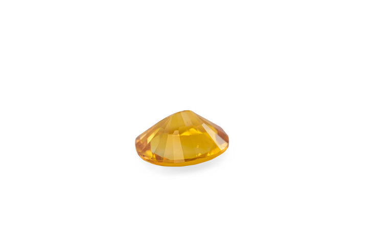 An oval cut rich golden yellow Ceylon sapphire gemstone displayed on a white background.