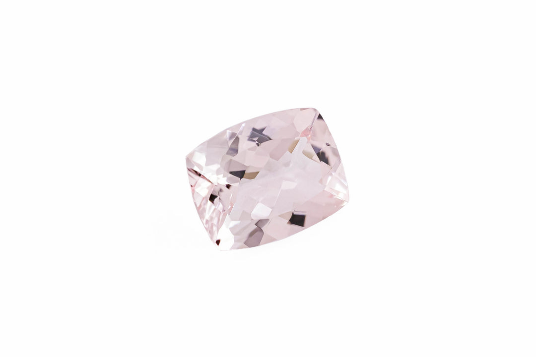A cushion cut pale pink morganite gemstone is displayed on a white background.