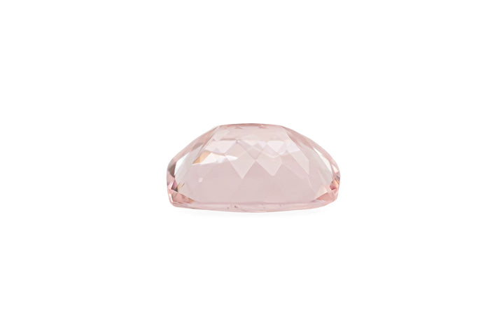 A cushion cut pale pink morganite gemstone is displayed on a white background.