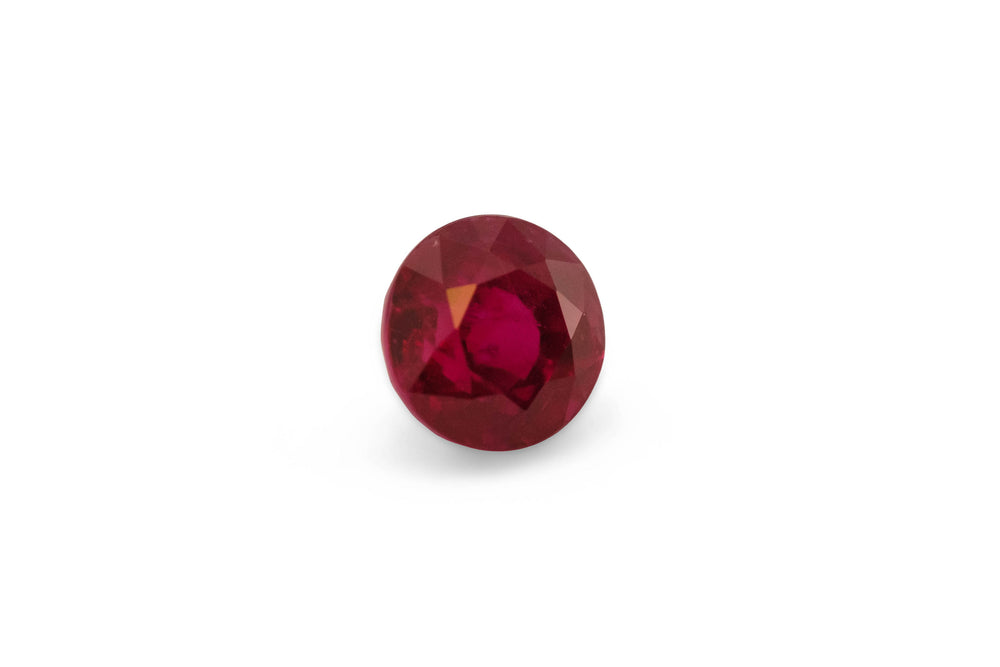 A round brilliant cut Burmese ruby gemstone is displayed on a white background.