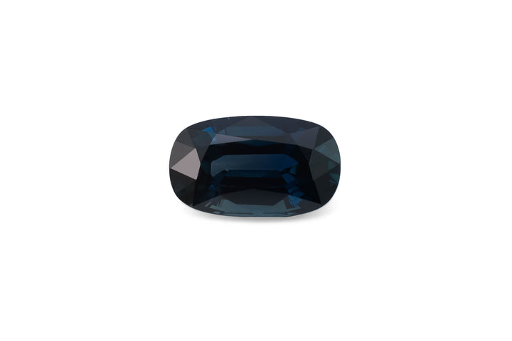 Cushion cut dark blue Australian sapphire gemstone on a white background.